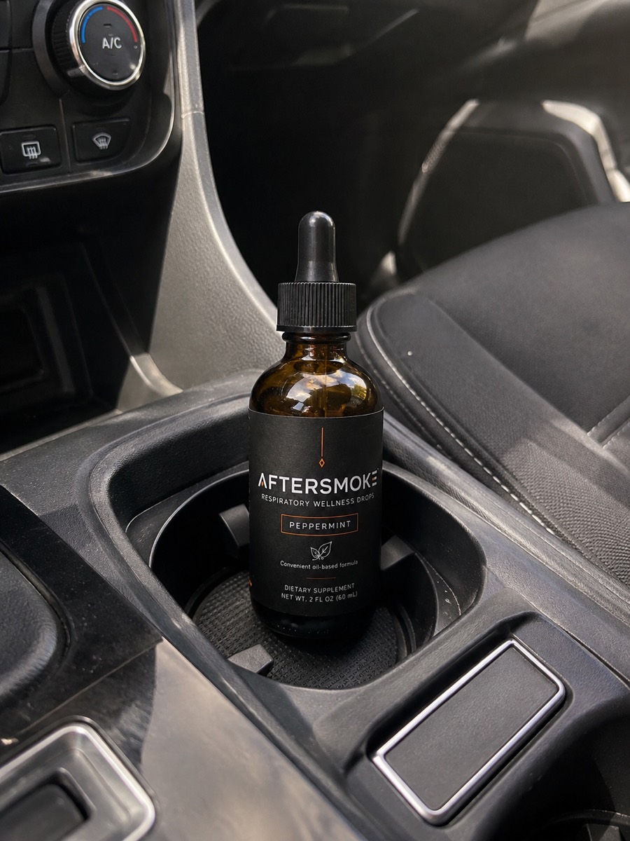 AfterSmoke bottle in a car cup holder